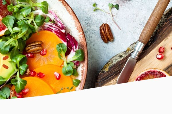 Bunte Salatschale mit Avocado, Kürbis, Granatapfelkernen, Blattsalat und Zitrusfrüchten