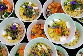 Bunte Auswahl an veganen Bowls mit frischem Gemüse, Kichererbsen, Tofu und essbaren Blüten, serviert beim Buffet im besten Seminarhotel Deutschlands.