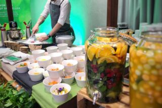 Cateringstation mit frischen Bowls, Kräutern und großen Gläsern mit Infused Water – serviert von Manss Foodservice beim Jubiläum des ATLANTIC Hotels Münster.