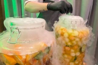 Zwei große Gläser mit Fruchtbowle dampfen eindrucksvoll durch Trockeneis